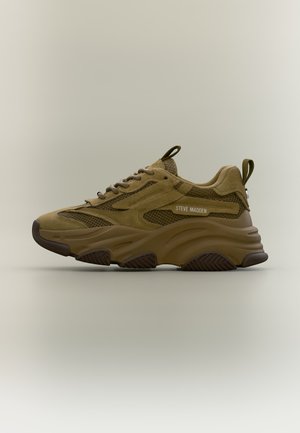 Baskets épaisses vert olive avec dessus en suède et mesh, semelle épaisse texturée, fermeture à lacets et languettes sur la languette et le talon.