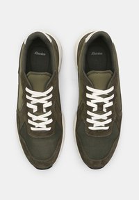 Oliivroheline sneaker, mis on valmistatud võrgust ja nubukist materjalidest, valged paelad ja kreemjas tald. Omab tekstuurset disaini ja pehmendatud sisemust.