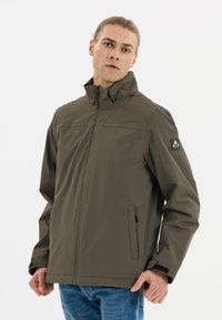 Grøn vandafvisende jakke med høj krave, frontlynlås, sidelommer og logo på ærmet. Glat tekstur og afslappet design.