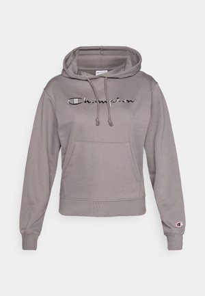 Pelēks džemperis ar kapuci un priekšējo kabatu, uz kura ir izšūta "Champion" logotips un ribota aproce. Izgatavots no mīksta auduma.