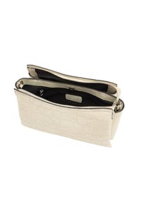 Kremowa torba ze teksturowanej skóry z wzorem krokodyla, z dwoma zamykanymi na zamek zasobnikami i czarnym wnętrzem z materiału.