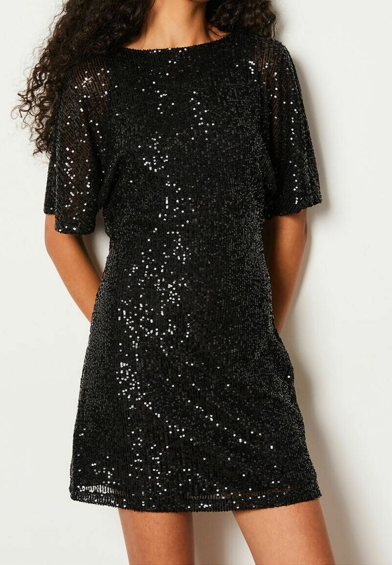Robe courte noire couverte de sequins, avec une coupe décontractée, des manches courtes et un col bateau. Texture lisse avec des détails brillants et réfléchissants.