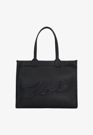 Czarna prostokątna skórzana torebka z dwoma uchwytami i wypukłym kursywnym logo „Karl” na środku przedniej części.