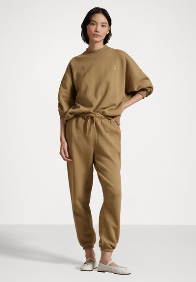 Brown sweatshirt and joggers made of soft fabric. Sweatshirt has a crew neck and relaxed fit; joggers feature an elastic waistband with drawstring.