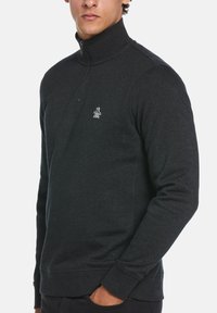 Dark gray zip-up sweatshirt with a high collar, ribbed cuffs, and a small white logo on the chest. Made of a soft, textured fabric.