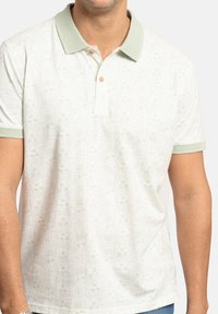 Polo de manga corta en verde claro y blanco, con un diseño estampado, cuello acanalado y placket de dos botones.