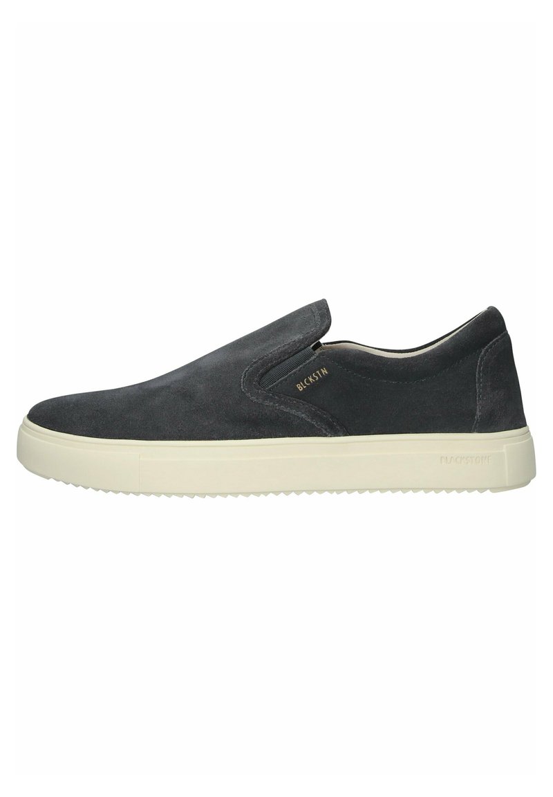 Scarpa slip-on in suede nero con accenti elastici ai lati, suola in gomma bianca e branding minimalista. Texture liscia e design elegante.