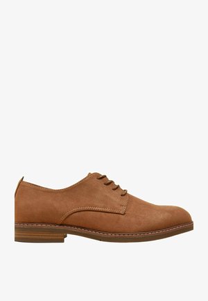 Chaussure habillée pour homme en daim marron avec lacets, petit talon empilé et semelle cousue, vue de côté sur fond blanc.
