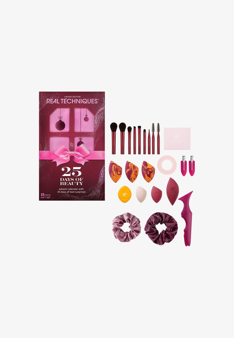 Set van 25 schoonheidsproducten, waaronder roze sponsen, borstels, scrunchies en een haaraccessoire in een versierde roze doos met een lint.