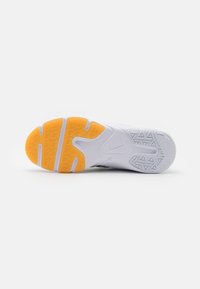 Nike shoe sole with white rubber, textured patterns, and a vibrant yellow accent. Features a herringbone tread for traction.