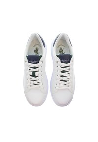 Valkoiset tenniskenkä, joissa on sileä nahkapinta, tummansinisiä yksityiskohtia kielellä ja vihreää yksityiskohtaa. Varustettu valkoisilla nauhoilla ja pyöreällä varvassuunnittelulla.