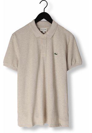 Polo beige à manches courtes avec col et deux boutons, arborant un petit logo crocodile vert sur la poitrine gauche, suspendu à un cintre noir.