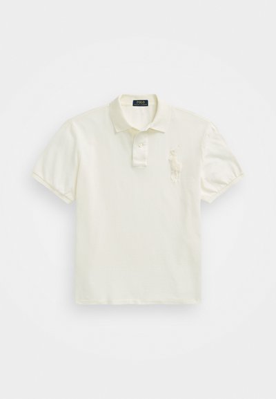 Kremna polo majica z odprtjem za tri gumbke, kratkimi rokavi in vezenim logotipom na levem prsnem delu. Mehka, gladka bombažna tkanina.