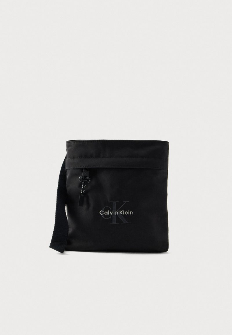 Borsa a tracolla in nylon nero con chiusura superiore, caratterizzata da una stampa con logo e tracolla regolabile. Texture liscia e design minimalista.