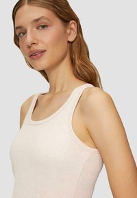 Helles rosa Tanktop aus einem weichen, strukturierten Stoff mit breiten Trägern, einem runden Halsausschnitt und sichtbaren Nähten.