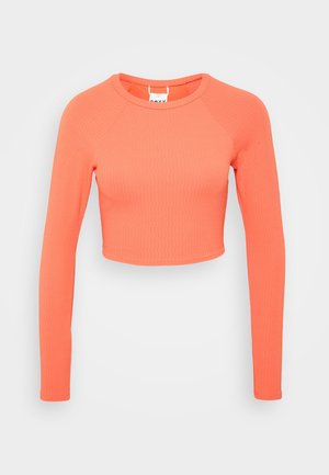 Langærmet, cropped top lavet af tekstureret, strækbart stof i en lys koralfarve. Har en rund halsudskæring og tætsiddende ærmer.