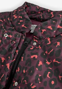 Gewatteerd jack met een bordeauxrode basis en zwarte en roze luipaardprint, ritssluiting, drukknoopsluitingen en een opstaande kraag. Zachte textuur.