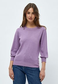 Lila Strickpullover mit Rundhalsausschnitt, 3/4 Puffärmeln sowie gerippten Bündchen und Saum. Kombiniert mit blauen Jeans.