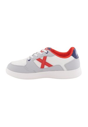 Zapatilla deportiva gris y blanca con parte superior de malla, acentuada por una "X" roja, suela de goma y forro rojo. Presenta un sistema de cordones tradicional.