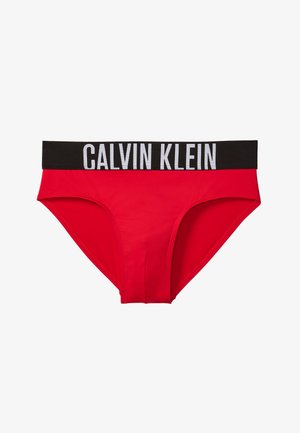 Rote Herren-Slips mit einem breiten schwarzen Bund, auf dem vorne in Weiß "Calvin Klein" steht.