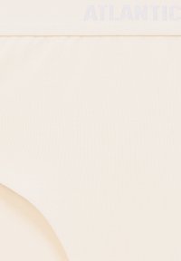 Beżowe bawełniane majtki o miękkiej, gładkiej fakturze oraz płaskim elastycznym pasie z nadrukiem "ATLANTIC" w jasnoniebieskim kolorze.