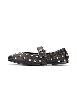 Zapato plano Mary Jane negro con tachuelas plateadas, una correa con hebilla sobre el empeine y un trasero elástico para un ajuste ceñido.