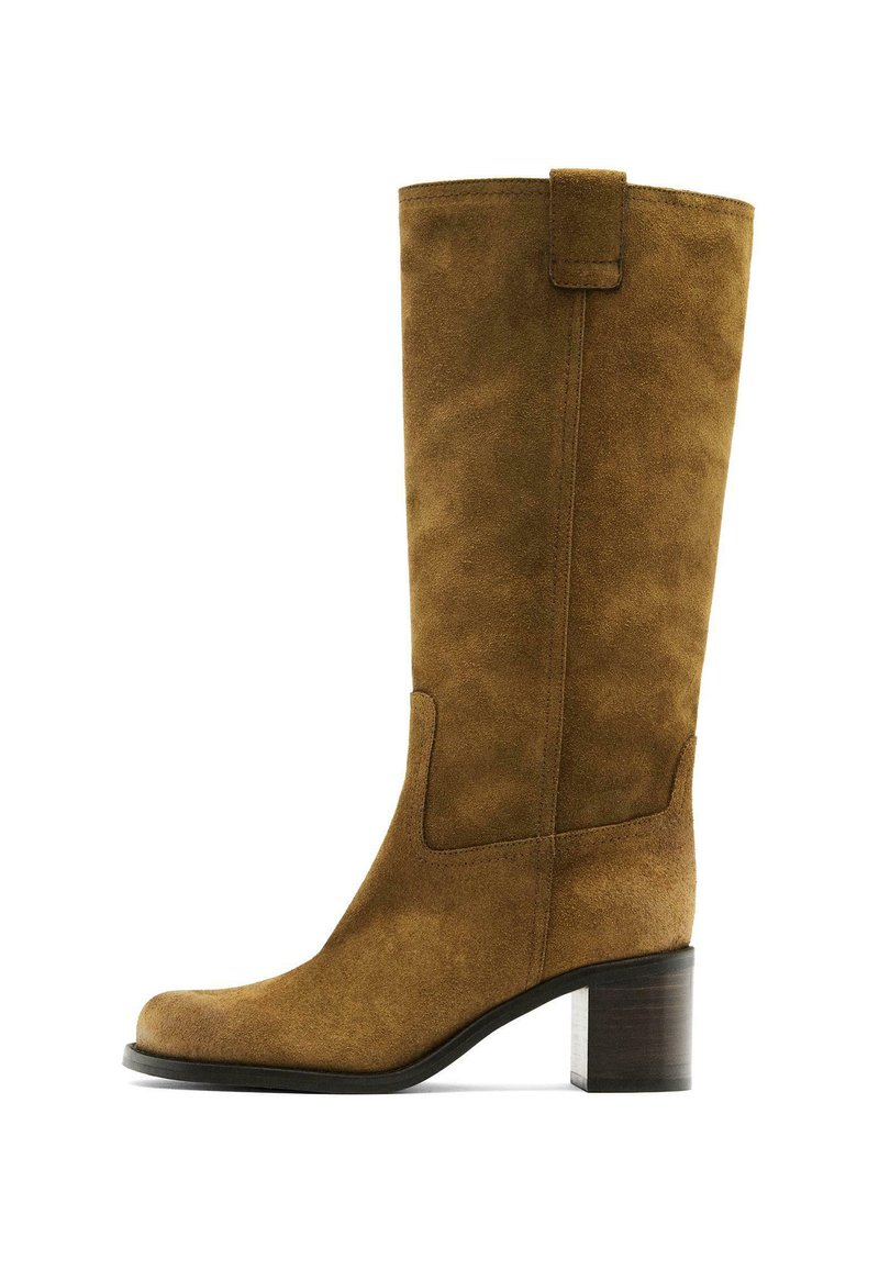 Stivale alto in suede marrone con punta quadrata, tacco a blocco e dettagli nei pannelli laterali. Texture liscia; design minimalista.