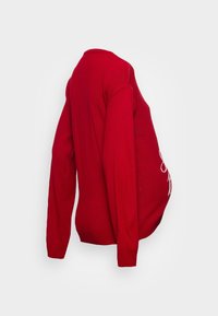 Roter gestrickter Umstands-Pullover mit langen Ärmeln, runder Ausschnitt und lockerer Passform, die Platz für einen wachsenden Bauch bietet.