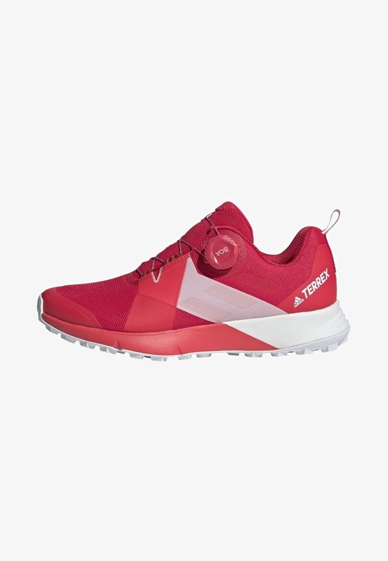 Chaussure de sport rouge Adidas Terrex avec semelle blanche, grip texturé et fermeture à lacets BOA sur le côté, vue de profil.