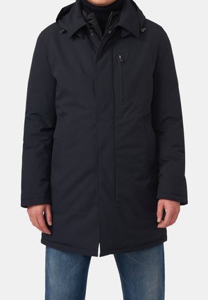 Marineblauwe gewatteerde jas met een capuchon, rits aan de voorkant, zijzakken en borstzak. Glad textuur, gemiddelde lengte en een relaxte pasvorm.