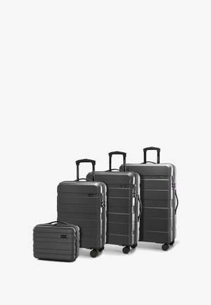 Quattro valigie rigide grigie di varie dimensioni, caratterizzate da scanalature orizzontali, manici telescopici e ruote scorrevoli per una maggiore mobilità.