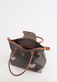 Bolso tote marrón con material sintético, acentos de cuero y un diseño divertido de corazón con ojos. Cierre de cremallera dorado y un bolsillo interior visible.