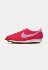 Tenis atlético de cor rosa brilhante com o swoosh da Nike em lavanda, sola intermédia branca, sola de borracha natural e parte superior em malha, mostrado em perfil lateral.