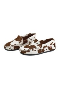 Zapatillas de casa de estampado de vaca en marrón y blanco, con suave piel texturizada, punta redondeada, costuras decorativas y suela negra flexible.