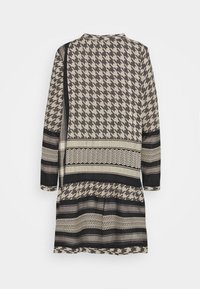 Vestido de manga larga con un patrón de pata de gallo y rayas en negro, beige y gris, mostrado desde la parte posterior sobre un fondo blanco.