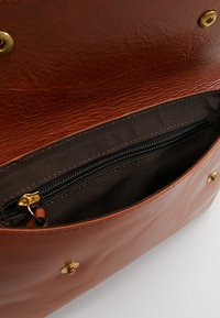Borsa in pelle marrone con una finitura testurizzata, dotata di una tasca con zip e dettagli in metallo dorato all'interno.