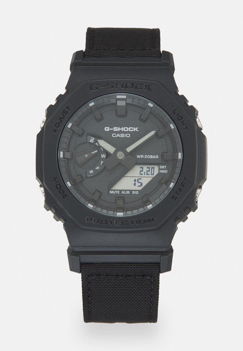 G-Shock-kello mustasta resinikotelosta ja kangashihnasta. Ominaisuuksiin kuuluu digitaalinen näyttö ja analoginen kellotaulu, teksturoitu kellotaulupinta sekä useita kellotauluja.