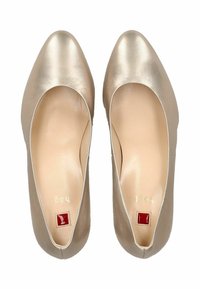 Ballerines en cuir beige avec un bout pointu, texture lisse et couture minimale. L'intérieur présente une marque dorée et un logo en accent rouge.