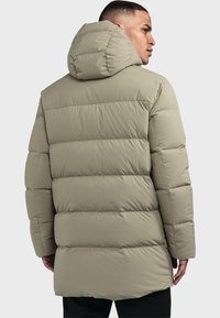 Daunenmantel in hellem Khaki mit Kapuze, gestepptem Design und langer Länge, aus glattem, gepolstertem Material.