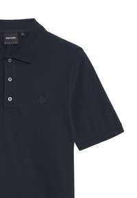 Polo navy de algodón, con un cuello clásico, tres botones, mangas cortas y un logotipo bordado tonal en el pecho.