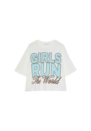 T-shirt blanc court avec un texte oversize bleu clair et marron indiquant « GIRLS RUN The World » sur le devant.