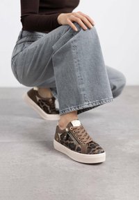 Zapatillas con estampado de leopardo en marrón y beige, con una parte superior texturizada, detalles en dorado y una suela de plataforma de color claro.
