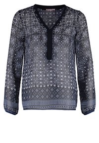 Blouse bleu marine transparente à manches longues avec des motifs géométriques et floraux blancs et un plastron en V bleu marine uni.