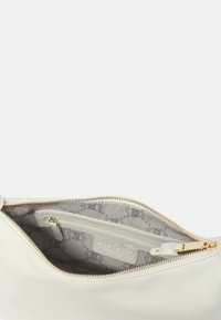 Borsa in pelle bianca con apertura con zip, caratterizzata da un interno grigio chiaro con un motivo sottile e una tasca piccola per l'organizzazione.