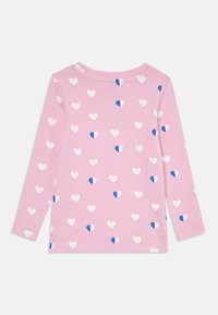 Långärmad rosa t-shirt med ett mönster av vita och blåa hjärtan på ett mjukt tyg, med rundad halsringning och rak fåll.