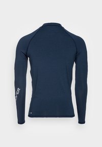 Camisa de rendimiento de manga larga en color navy, con un diseño ajustado y una textura suave. Logo impreso en la manga izquierda, costuras mínimas para mayor comodidad.