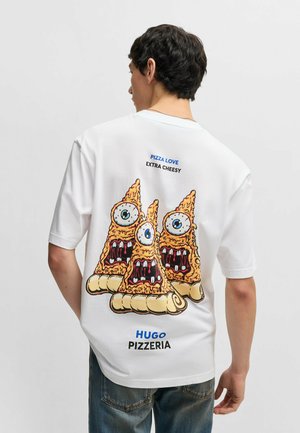 White t-shirt featuring a cartoon graphic of three pizza slices with exaggerated eyes and mouths, labeled "PIZZA LOVE EXTRA CHEESY HUGO PIZZERIA."