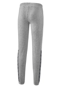 Graue Jogginghosen mit einem elastischen Bund und seitlichen Streifen, die ein dunkles Muster entlang der äußeren Nähte aufweisen. Aus weichem Baumwollgemisch.