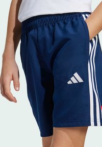Navy blue athletic shorts with an elastic waistband, featuring white striped accents on the sides and a white logo on the hem.