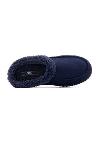 Zapatilla de color azul marino con un cuello de felpa y material suave. Presenta un borde cosido y una suela texturizada para mayor agarre. Etiqueta de la marca visible.